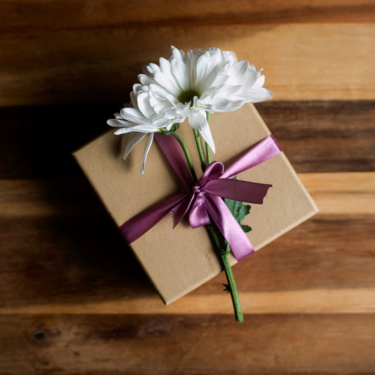 Brown gift box with a white flower
